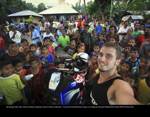 June: by George Guille, Sark, Channel Islands. Drawing a crowd on Flores, Indonesia - 'You are the first Westerner to stay in our village for 40 years!' Riding RTW; Honda XRV750 Africa Twin.