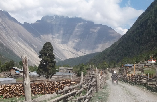 John riding on dusty Nepal road