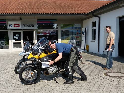 Ekke gives his bike a hug when he sees it while Michael Zierer looks on in bemusement.